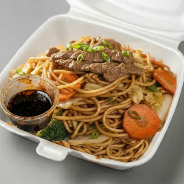 Beef lo mein with vegetables and a side of sauce in a white takeout container.